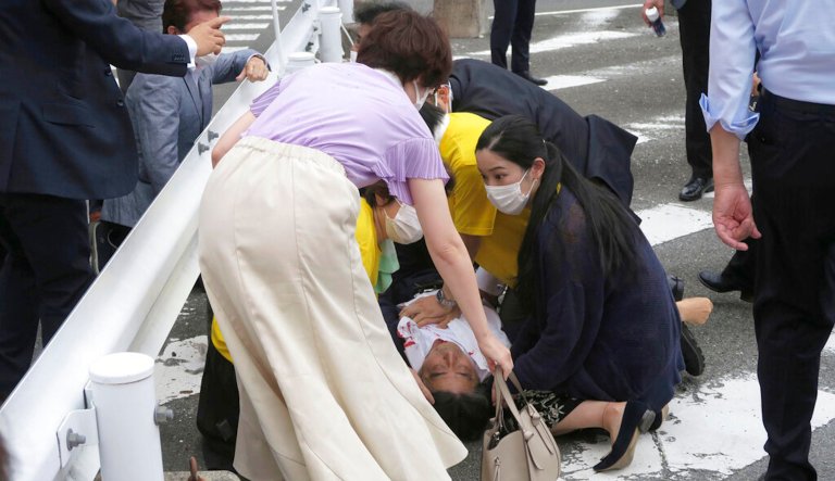 Former Japanese Prime Minister Shinzo Abe, center, falls on the ground in Nara.