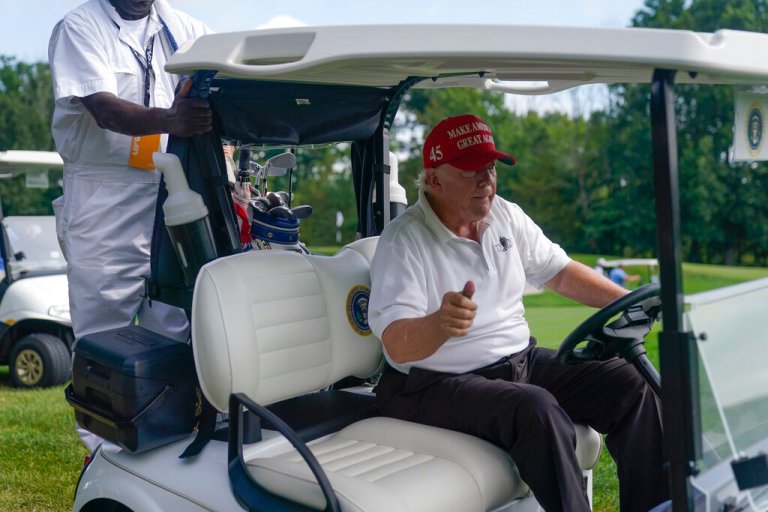 Former President Donald Trump shows a thumbs-up while playing during the pro-am round of the Bedminster Invitational LIV Golf tournament on July 28. The presidential seal can be seen on his seat.