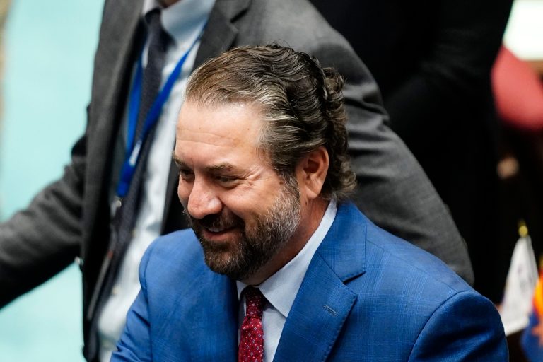 Mark Brnovich smiles as he talks with people on the floor of the Arizona House of Representatives, at the Arizona Capitol, Jan. 10, 2022, in Phoenix. (AP Photo/Ross D. Franklin)