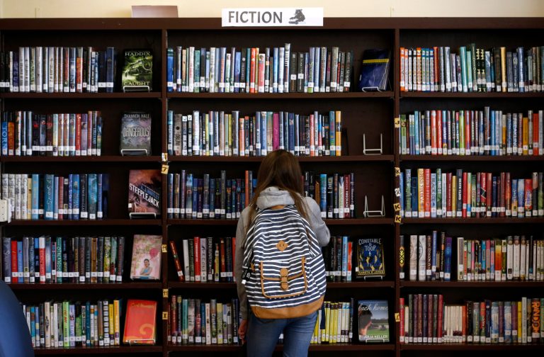 A student browses through books in the Presidio Middle School library in San Francisco, Calif. on Tuesday, Sept. 10, 2019. A school district in Texas has removed dozens of books and is reviewing them before returning the books to their shelves. (Paul Chinn/San Francisco Chronicle via AP)