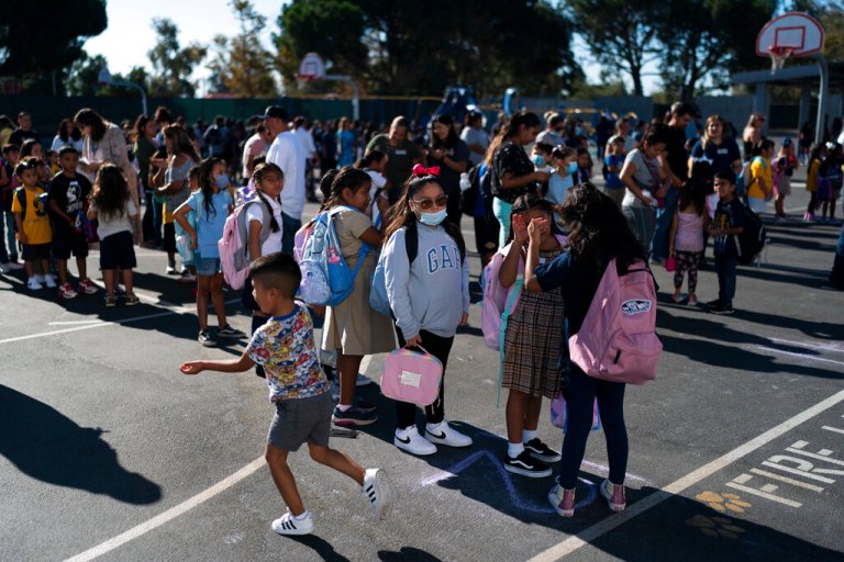 Students wait in line before heading to their classrooms on the first day back to school at Sunkist Elementary School in Anaheim, Calif., Thursday, Aug. 11, 2022. 