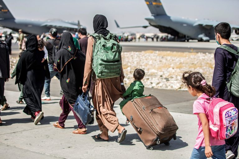 Families walk towards their flight during ongoing evacuations at Hamid Karzai International Airport, in Kabul, Afghanistan, on Aug. 24, 2021. 