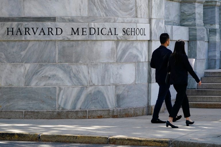 Pedestrians walk towards the Harvard Medical School, Thursday, Aug. 18, 2022, in Boston. 