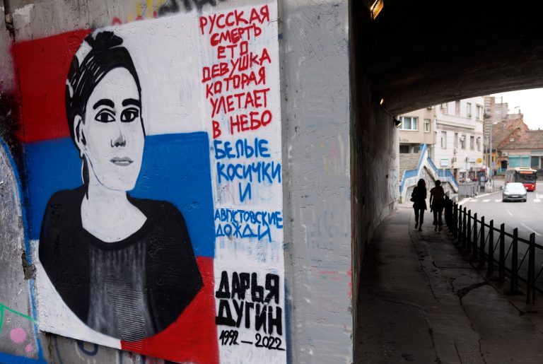 People pass by a mural depicting Daria Dugina, daughter of philosopher Alexander Dugin, in Belgrade, Serbia.