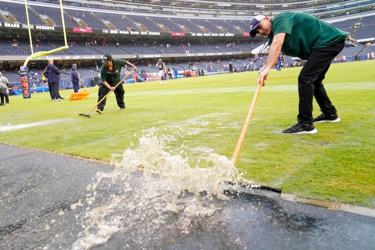Workers remove water from Soldier Field before an NFL football game between the Chicago Bears and the San Francisco 49ers Sunday, Sept. 11, 2022, in Chicago.