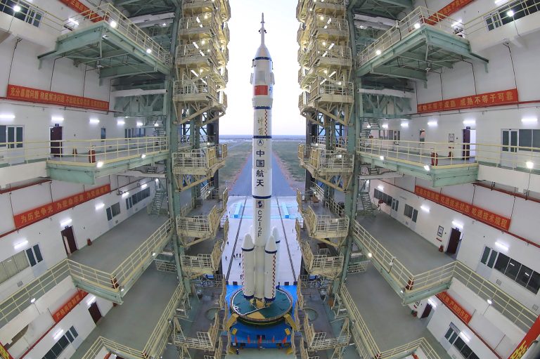 In this photo released by Xinhua News Agency, the Shenzhou-13 manned spaceship onto a Long March-2F carrier rocket prepares to be transferred to the launching area of Jiuquan Satellite Launch Center in northwestern China, Oct. 7, 2021. 