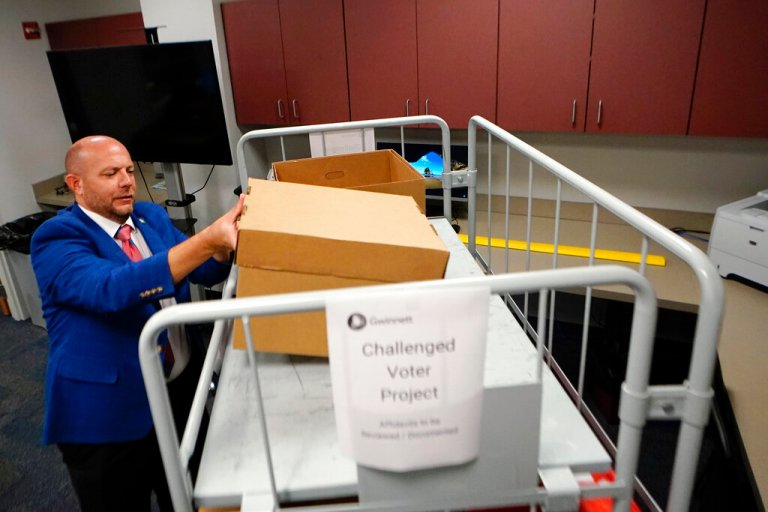 Gwinnett County elections supervisor Zach Manifold looks over boxes of voter challenges on Thursday, Sept. 15, 2022, in Lawrenceville, Georgia.