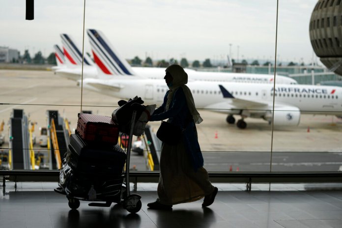 A traveler pulls her trolley Friday, Sept. 16, 2022 at Roissy Charles de Gaulle airport, north of Paris. Many domestic and some international flights were canceled in France Friday as air traffic controllers went on a national strike over pay and recruitment issues. French civil aviation authority DGAC warned that domestic traffic would be "severely disrupted" with many flights canceled and other experiencing long delays. Travelers have been advised to postpone their trip if possible. 