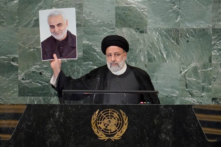 President of Iran Ebrahim Raisi holds up a photo of slain Iranian Gen. Qassem Soleimani as he addresses the 77th session of the United Nations General Assembly on Sept. 21, 2022, at U.N. headquarters. 
