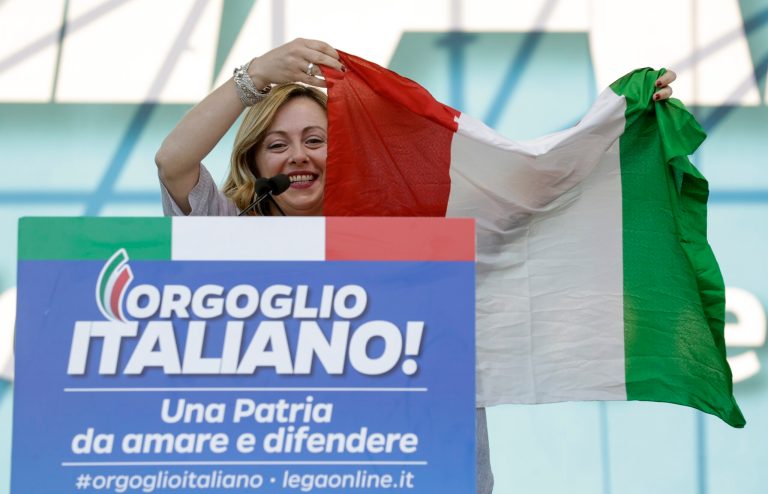 FILE - 'Brothers of Italy's Giorgia Meloni holds an Italian flag as she addresses a rally in Rome, Saturday, Oct. 19, 2019.