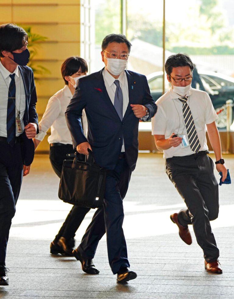Japanese Chief Cabinet Secretary Hirokazu Matsuno, center, arrives at the prime minister's office in Tokyo.