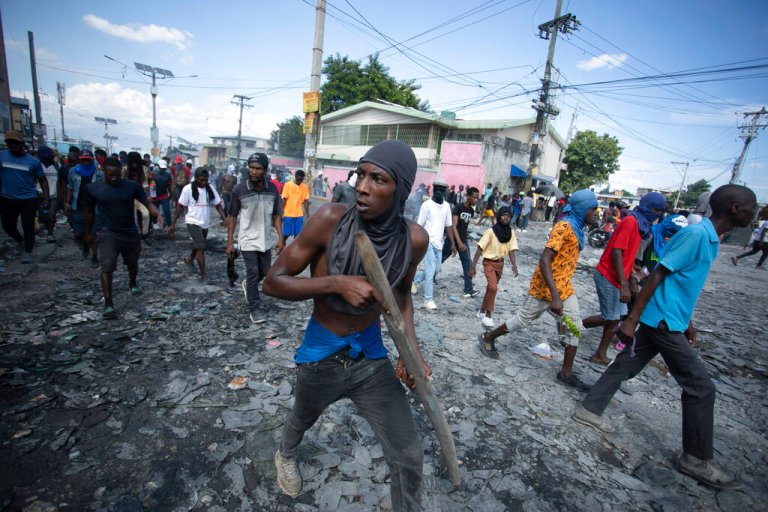 FILE - A protester carries a piece of wood simulating a weapon during a protest demanding the resignation of Prime Minister Ariel Henry, in the Petion-Ville area of Port-au-Prince, Haiti, Oct. 3, 2022. Haiti's government has agreed to request the help of international armed forces as gangs and protesters paralyze the country and basic supplies including fuel and water dwindle, a top ranking Haitian official told The Associated Press on Friday, Oct 7. 