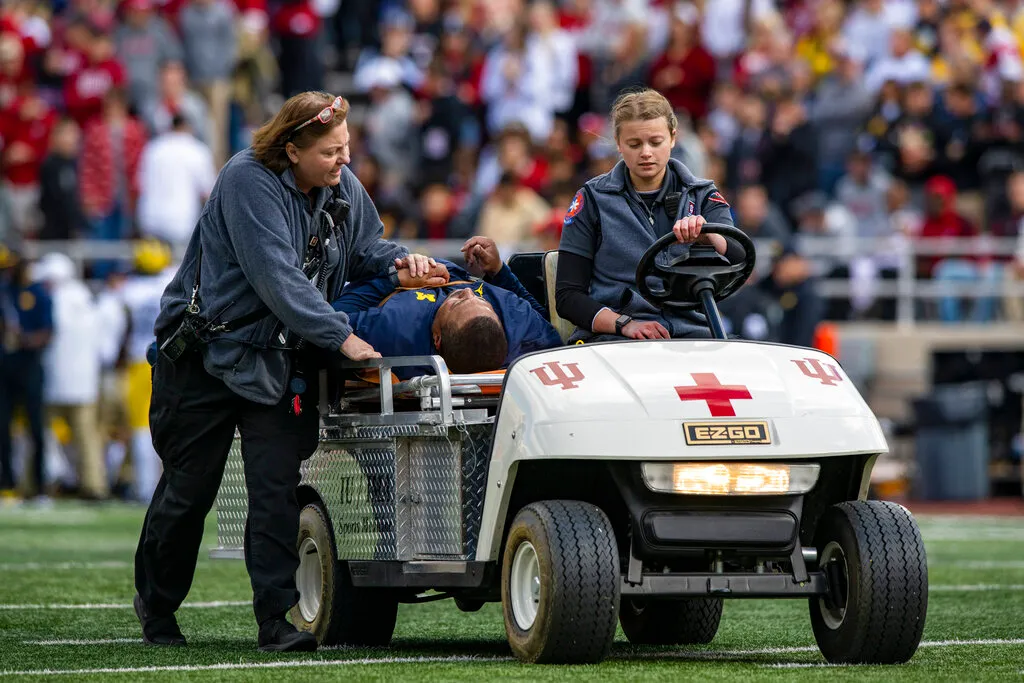 Michigan running back coach Mike Hart collapses on the sidelines
