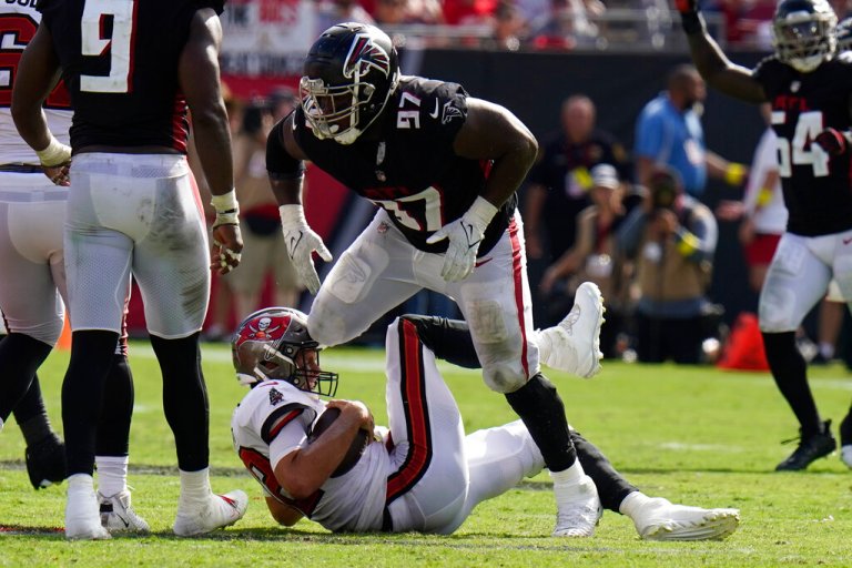 Atlanta Falcons defensive end Grady Jarrett (97) takes down Tampa Bay Buccaneers quarterback Tom Brady (12) during the second half of an NFL football game Sunday, Oct. 9, 2022, in Tampa, Fla. Jarrett was called for a penalty. 