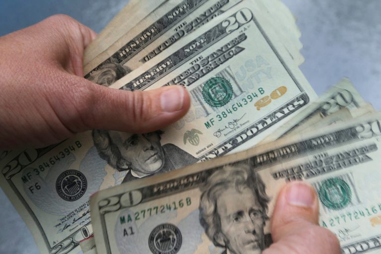FILE - In this June 15, 2018 file photo, twenty dollar bills are counted in North Andover, Massachusetts. The paper checks worth $300 are slated to go out the week of Oct. 17, according to Hawaii's tax department. (AP Photo/Elise Amendola, File)