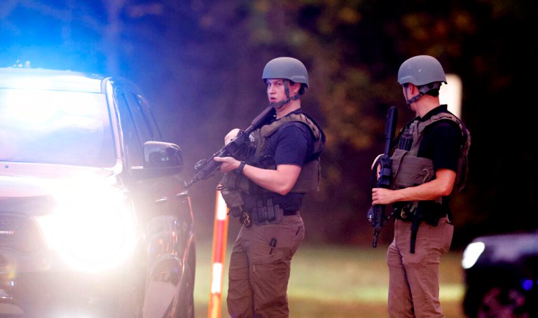 Law enforcement stand at the entrance to Neuse River Greenway Trail parking at Abington Lane following a shooting in Raleigh, N.C., Thursday, Oct. 13, 2022. 