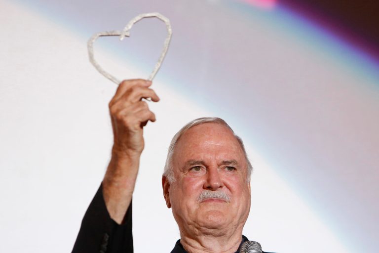 FILE - John Cleese poses for photos with Sarajevo Film Festival's top honour award, the Heart of Sarajevo Award, in Sarajevo, Bosnia, on Aug. 16, 2017. Cleese turned 83 on Oct. 27. (AP Photo/Amel Emric, File)
