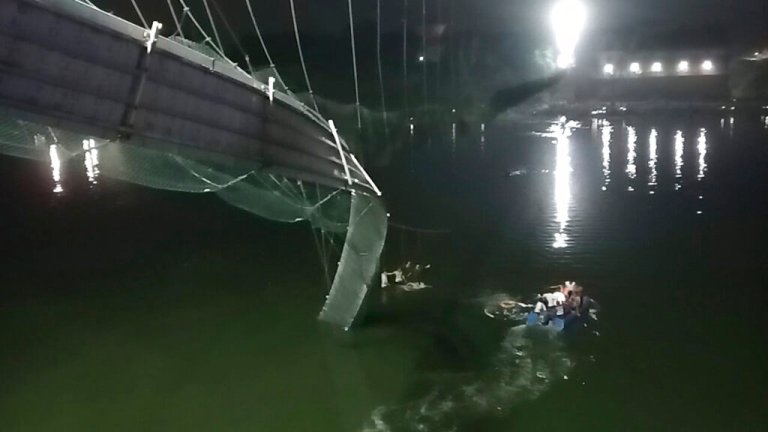 Rescuers on boats search in the Machchu river next to a cable bridge that collapsed in Morbi district, western Gujarat state, India, Sunday, Oct.30, 2022. Dozens are feared dead and several are injured in the accident. 