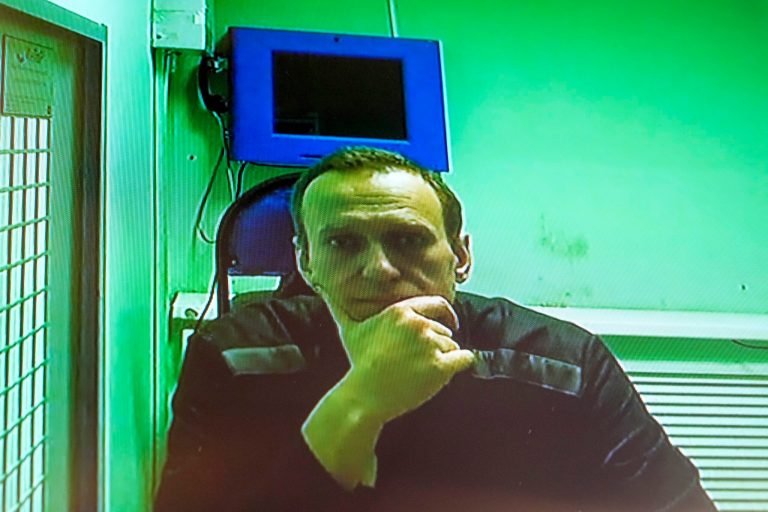 FILE - Russian opposition leader Alexei Navalny is seen on a TV screen, as he appears in a video link provided by the Russian Federal Penitentiary Service in a courtroom of the Second Cassation Court of General Jurisdiction in Moscow, Russia, Tuesday, Oct. 18, 2022. A judge in the Vladimir regional city of Kovrov on Nov. 10 dismissed Alexei Navalny's protest against his confinement in a punishment cell. (AP Photo/Alexander Zemlianichenko, File)