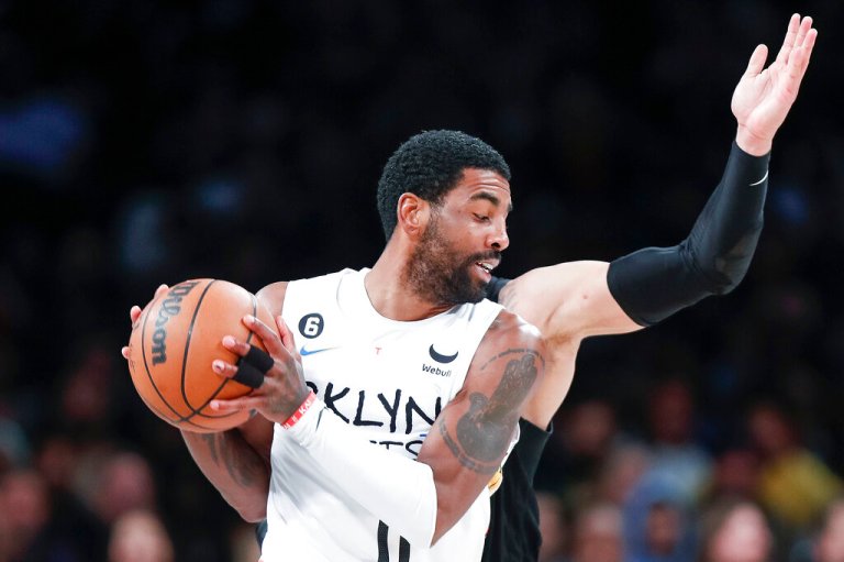 Memphis Grizzlies forward Dillon Brooks, back, defends against Brooklyn Nets guard Kyrie Irving (11) during the second half of an NBA basketball game Sunday, Nov. 20, 2022, in New York. 