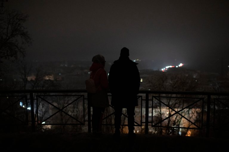 People stand amid a blackout after a Russian rocket attack in Kyiv, Ukraine, Wednesday, Nov. 23, 2022. Russia unleashed a new missile onslaught on Ukraine's battered energy grid Wednesday, robbing cities of power and some of water and public transport, compounding the hardship of winter for millions.