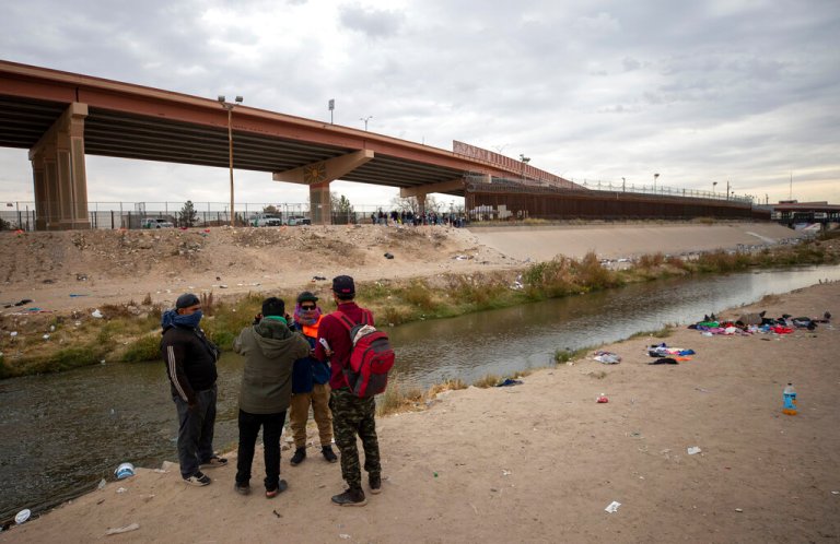 A small group of migrants discuss whether or not to cross the Rio Grande from Ciudad Juarez, Mexico and surrender to the Border Patrol in El Paso, Texas, Sunday, Dec. 18, 2022. 
