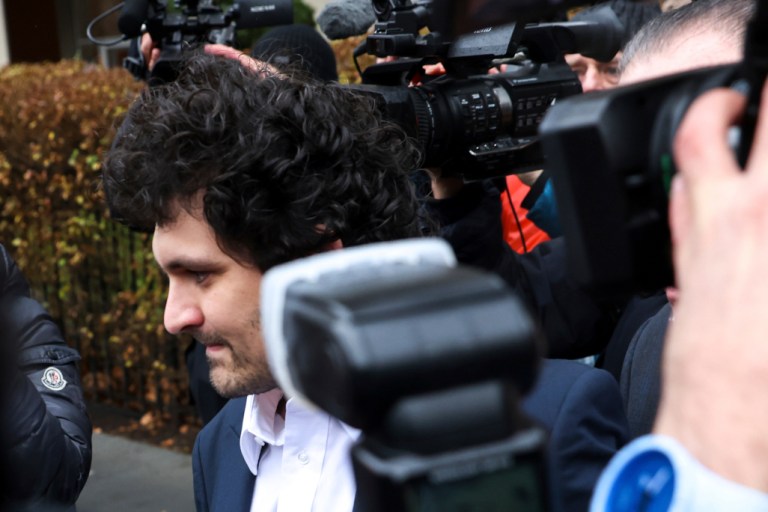 FTX founder Sam Bankman-Fried is escorted to his car from the U.S. District Court in Manhattan, on Thursday, Dec. 22, 2022, in New York.