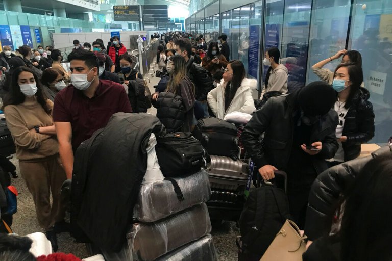 Inbound travelers wait for hours to board buses to leave for quarantine hotels and facilities from Guangzhou Baiyun Airport in southern China's Guangdong province on Dec. 25 2022. 