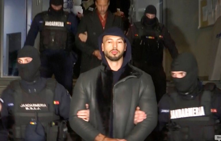 In this grab taken from video released by Observator Antena 1, social media personality Andrew Tate is led away by police.