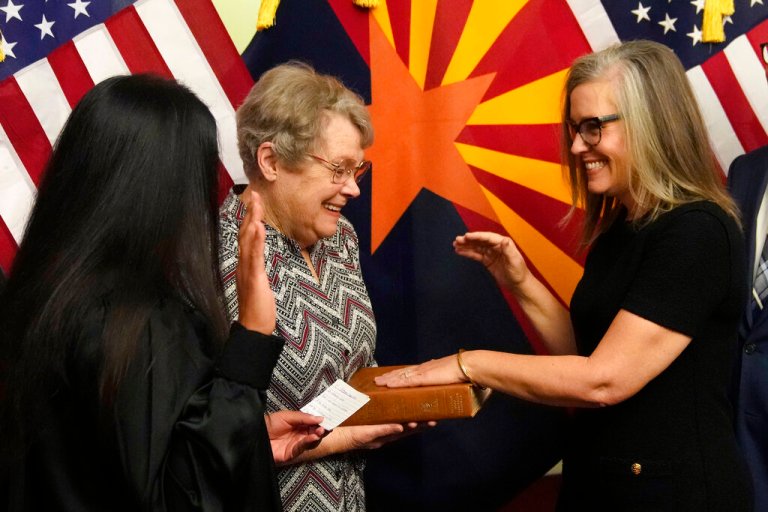 The new Arizona Democratic Gov. Katie Hobbs, right, pauses during taking the oath of office in a ceremony as she laughs with her mother Linda Hobbs, who was emotional in the moment, Monday, Jan. 2, 2023. (AP Photo/Ross D. Franklin, Pool)