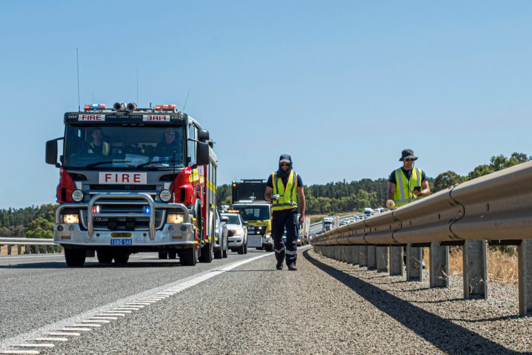 In this photo provided by the Department of Fire and Emergency Services, its members search for a radioactive capsule believed to have fallen off a truck.