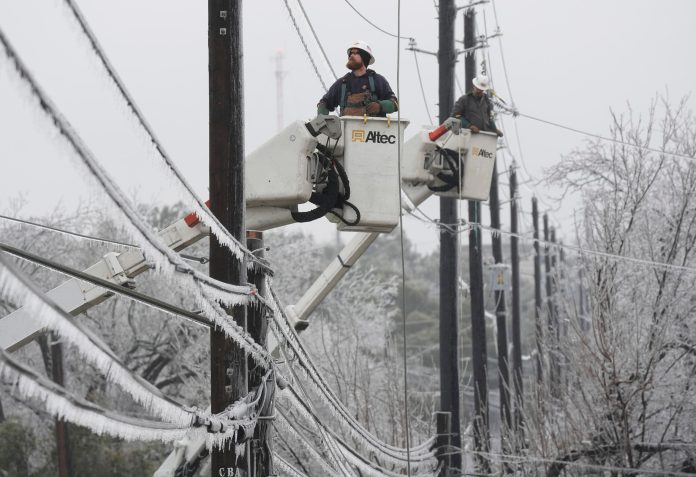 Austin Energy linemen Ken Gray, left, and Chad Sefcik work to restore power on ice-covered lines along West Alpine Road during a winter storm, Wednesday, Feb. 1, 2023, in Austin, Texas.