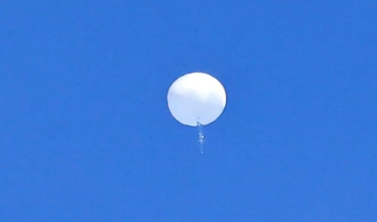 In this photo provided by Travis Huffstetler Photography, a large balloon drifts above the Atlantic Ocean, just off the coast of the Carolinas, Saturday, Feb. 4, 2023. The massive white orb that drifted across U.S. airspace this week and was shot down by the Air Force over the Atlantic on live television Saturday triggered a diplomatic maelstrom and blew up on social media.