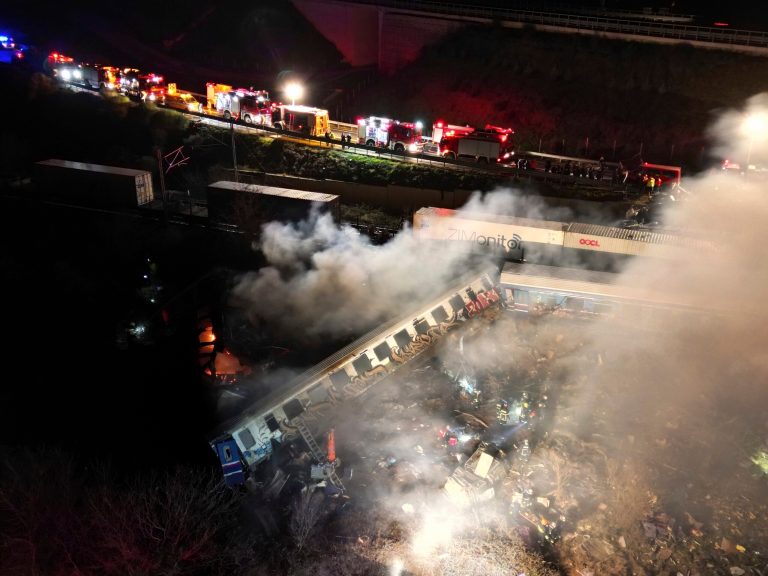 Smoke rises from trains as firefighters and rescuers operate after a collision near Larissa city, Greece, early Wednesday, March 1, 2023. 