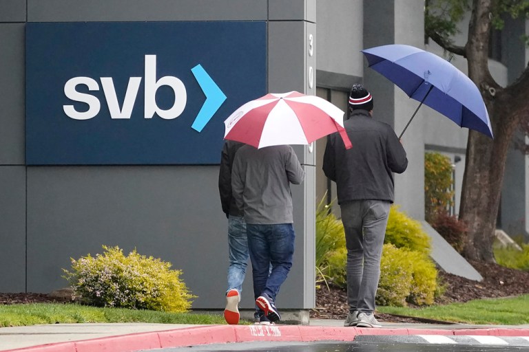 People walk past a Silicon Valley Bank sign at the company's headquarters in Santa Clara, Calif., Friday, March 10, 2023. The Federal Deposit Insurance Corporation is seizing the assets of Silicon Valley Bank, marking the largest bank failure since Washington Mutual during the height of the 2008 financial crisis. The FDIC ordered the closure of Silicon Valley Bank and immediately took position of all deposits at the bank Friday.