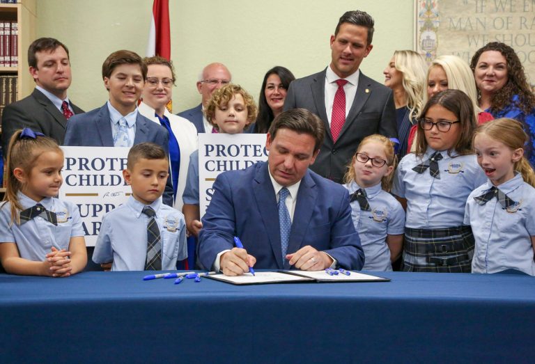 FILE - Florida Gov. Ron DeSantis signs the Parental Rights in Education bill at Classical Preparatory school on March 28, 2022, in Shady Hills, Fla.