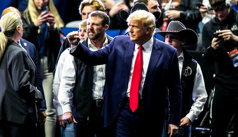 Former President Donald Trump greets fans as he arrives before the finals during the NCAA Wrestling Championships on Saturday, March 18, 2023.