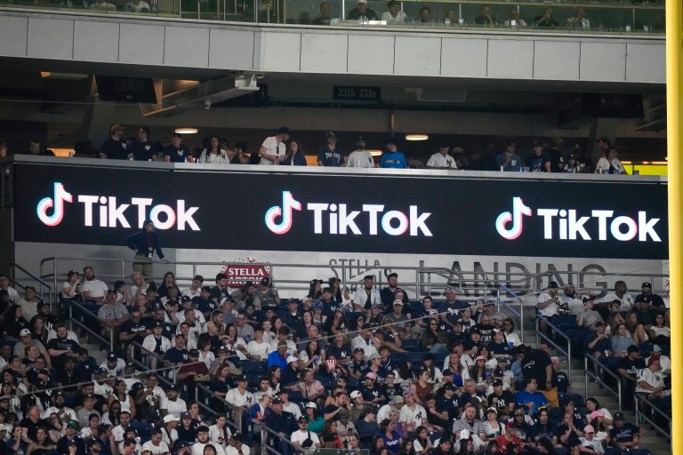 Fans stand near a TikTok logo during the fourth inning of a baseball game between the New York Yankees and the Minnesota Twins on Friday, April 14, 2023, in New York. The government and TikTok resumed negotiations on TikTok's availability in the United States in September 2023.