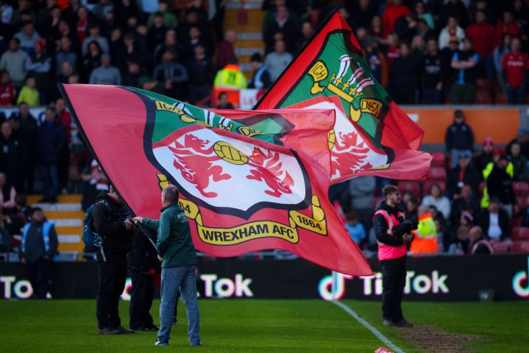 Banners are waved on the pitch before the National League soccer match between Wrexham and Yeovil Town at the Racecourse Ground, Wrexham, Wales, Tuesday, April 18, 2023. 