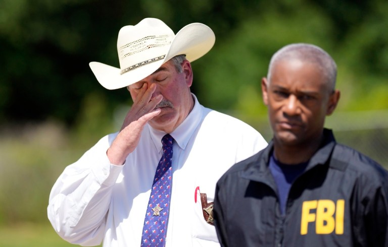 San Jacinto County Sheriff Greg Capers, left, wipes his eye as FBI Houston Special Agent in Charge James Smith speaks during a news conference, April 30, 2023, in Cleveland, Texas.