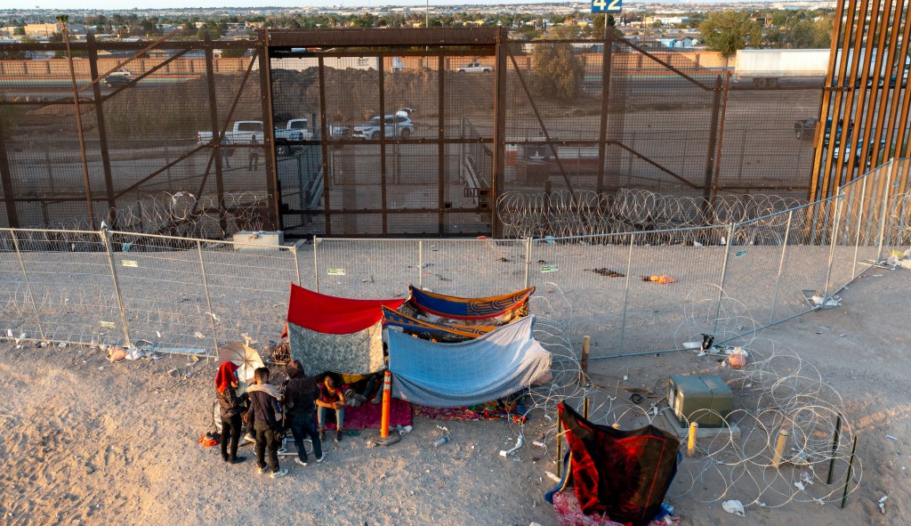 Immigrants parade across El Paso border in chaotic scene