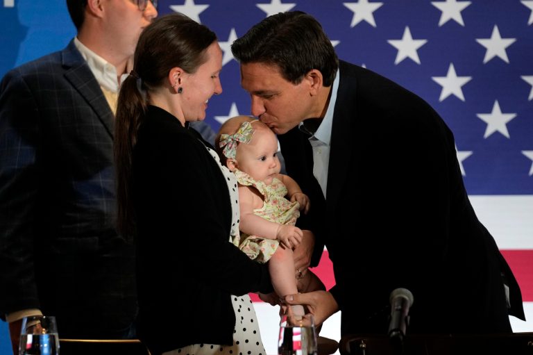 Florida Gov. Ron DeSantis kisses State Rep. Leah Cushman's daughter, Savannah, at a political roundtable, Friday, May 19, 2023, in Bedford, N.H.