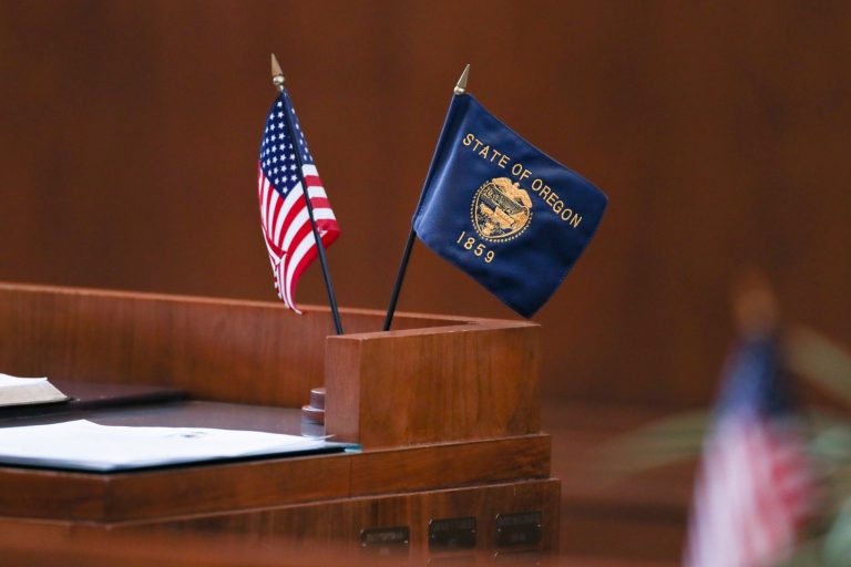 Flags sit on the desk of Republican Sen. Lynn Findley during a Senate session at the Oregon State Capitol in Salem, Ore., Tuesday, June 6, 2023. (AP Photo/Amanda Loman)