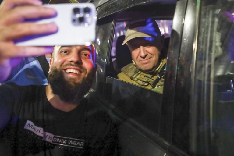 Yevgeny Prigozhin, the owner of the Wagner Group military company, right, sits inside a military vehicle posing for a selfie photo with a local civilian on a street in Rostov-on-Don, Russia, Saturday, June 24, 2023. 
