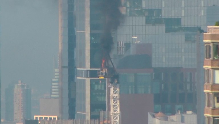 Emergency responders battle flames as a large construction crane caught fire in Manhattan on Wednesday, July 26, 2023, in New York.  