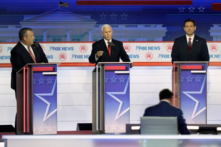 Former Vice President Mike Pence speaks as former New Jersey Gov. Chris Christie, left, and Gov. Ron DeSantis (R-FL) listen during a Republican presidential primary debate hosted by Fox News on Wednesday, Aug. 23, 2023, in Milwaukee.