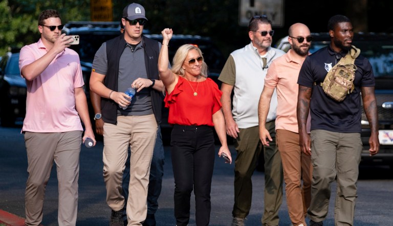 Rep. Marjorie Taylor Greene, R-Ga., cheers supporters of former President Donald Trump as she walks out of the Fulton County Jail parking lot in Atlanta on Thursday, Aug. 24, 2023.