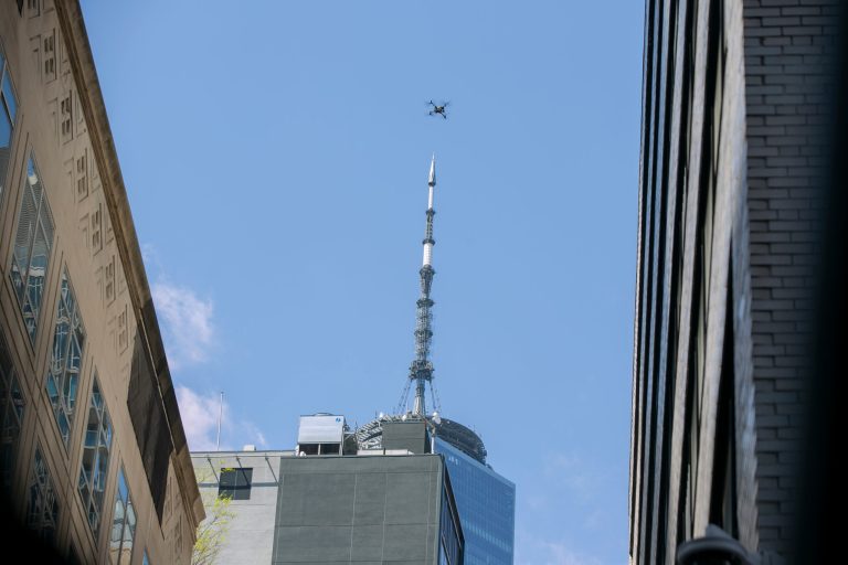 An NYPD or FDNY drone flies over the site of a partially collapsed parking garage as One World Trade Center is visible in the background in New York City, April 19, 2023. 