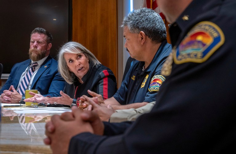 Gov. Michelle Lujan Grisham, second from left, with Deputy Cabinet Secretary of the Department of Public Safety Benjamin Baker, left, and Albuquerque Police Chief Harold Medina, right, speaks during a news conference, Friday, Sept. 8, 2023, in Santa Fe, New Mexico.  