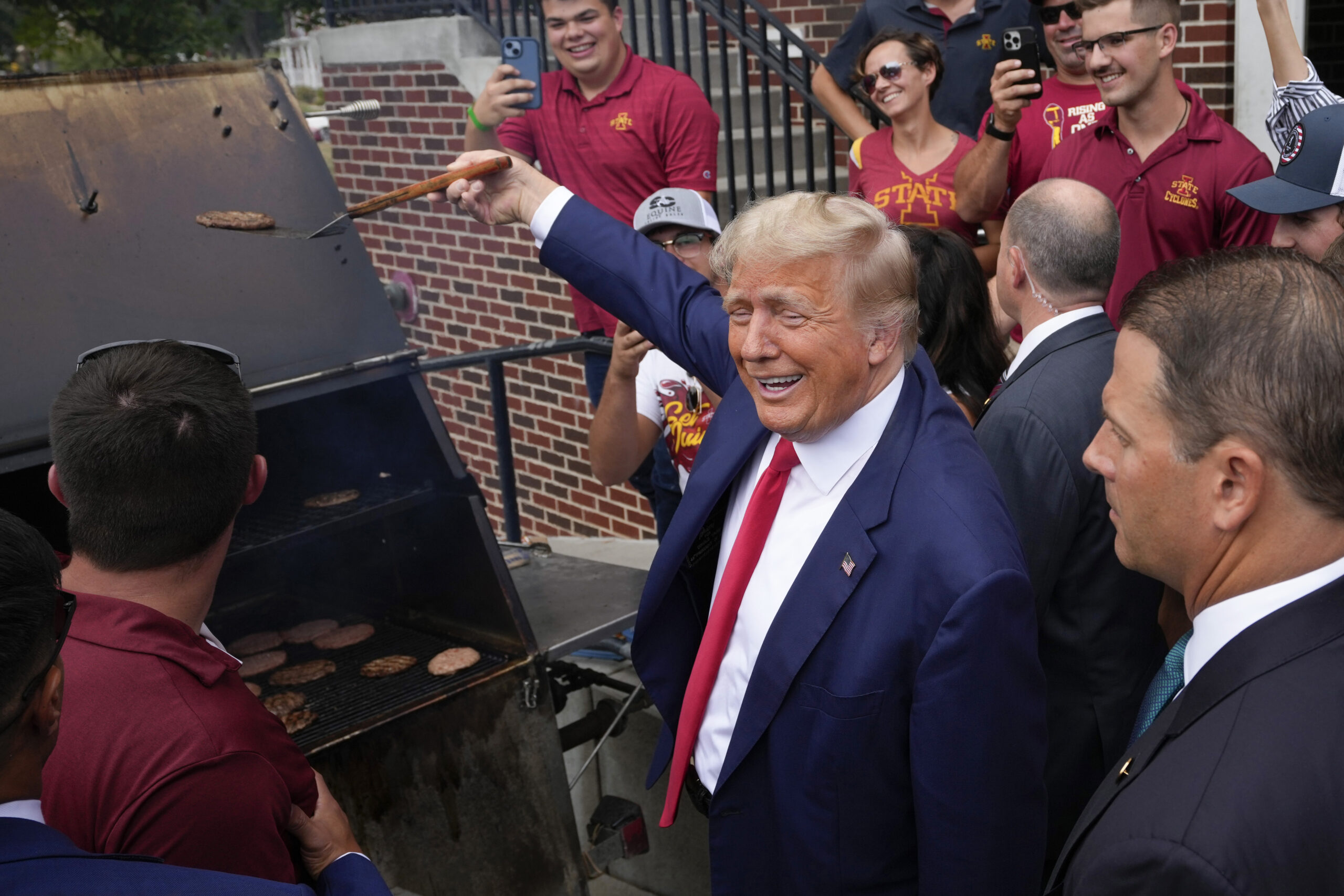 Trump flips burgers with fans at tailgate for Iowa-Iowa State matchup